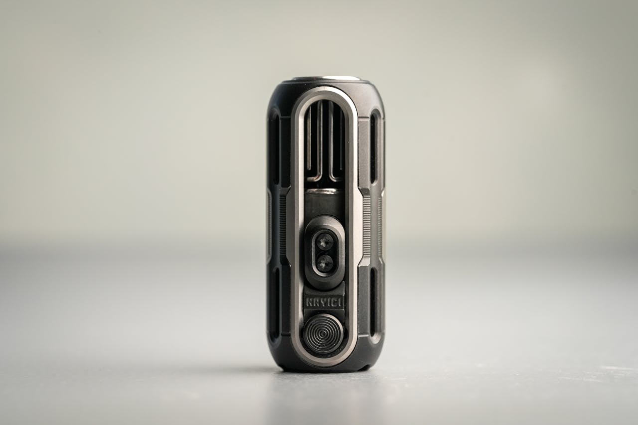 Sleek futuristic gadget with modern design standing vertically on a minimalist surface.